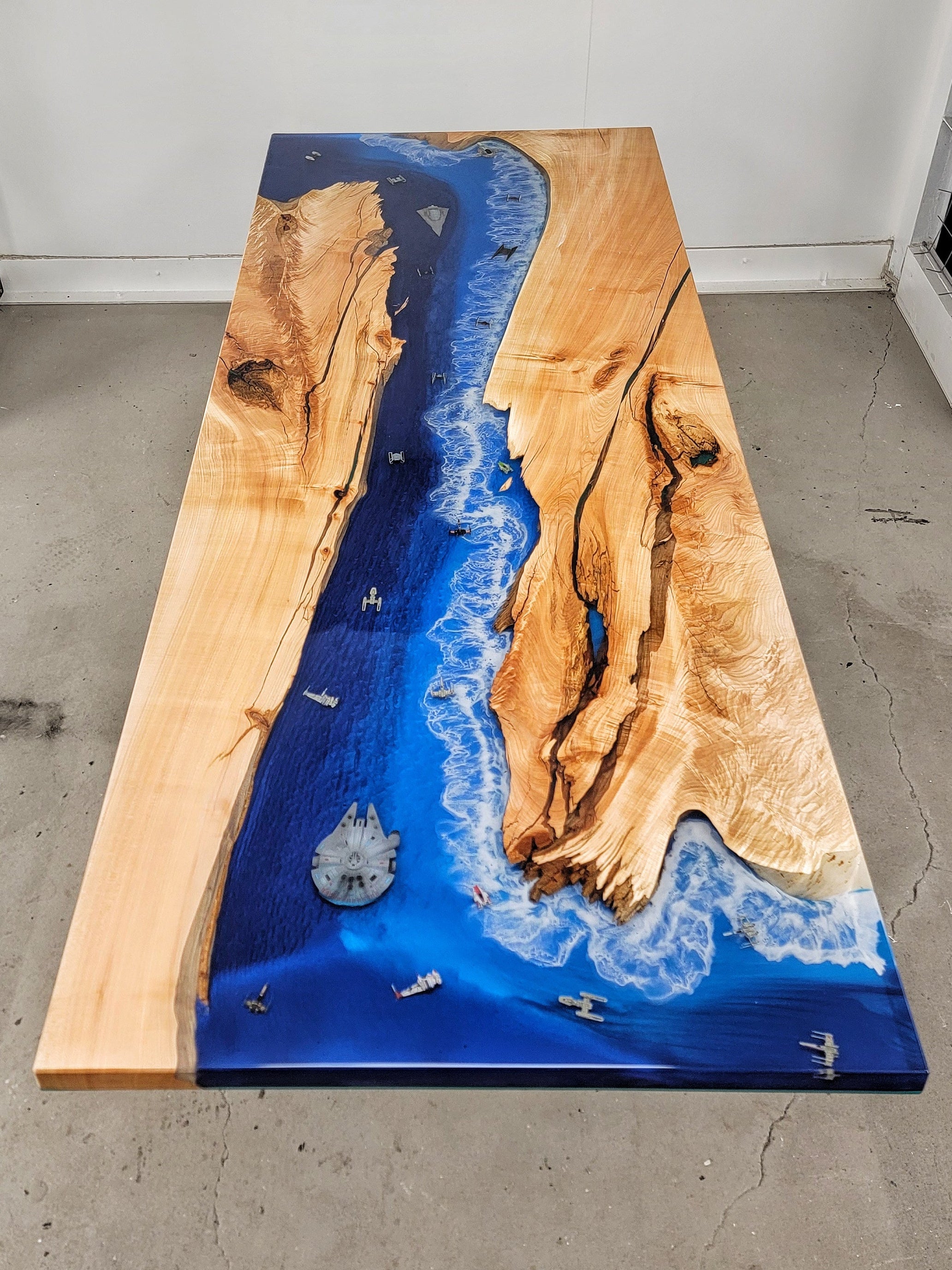 Maple wooden bar top with ocean-style resin as central river with Star Wars ships embedded
