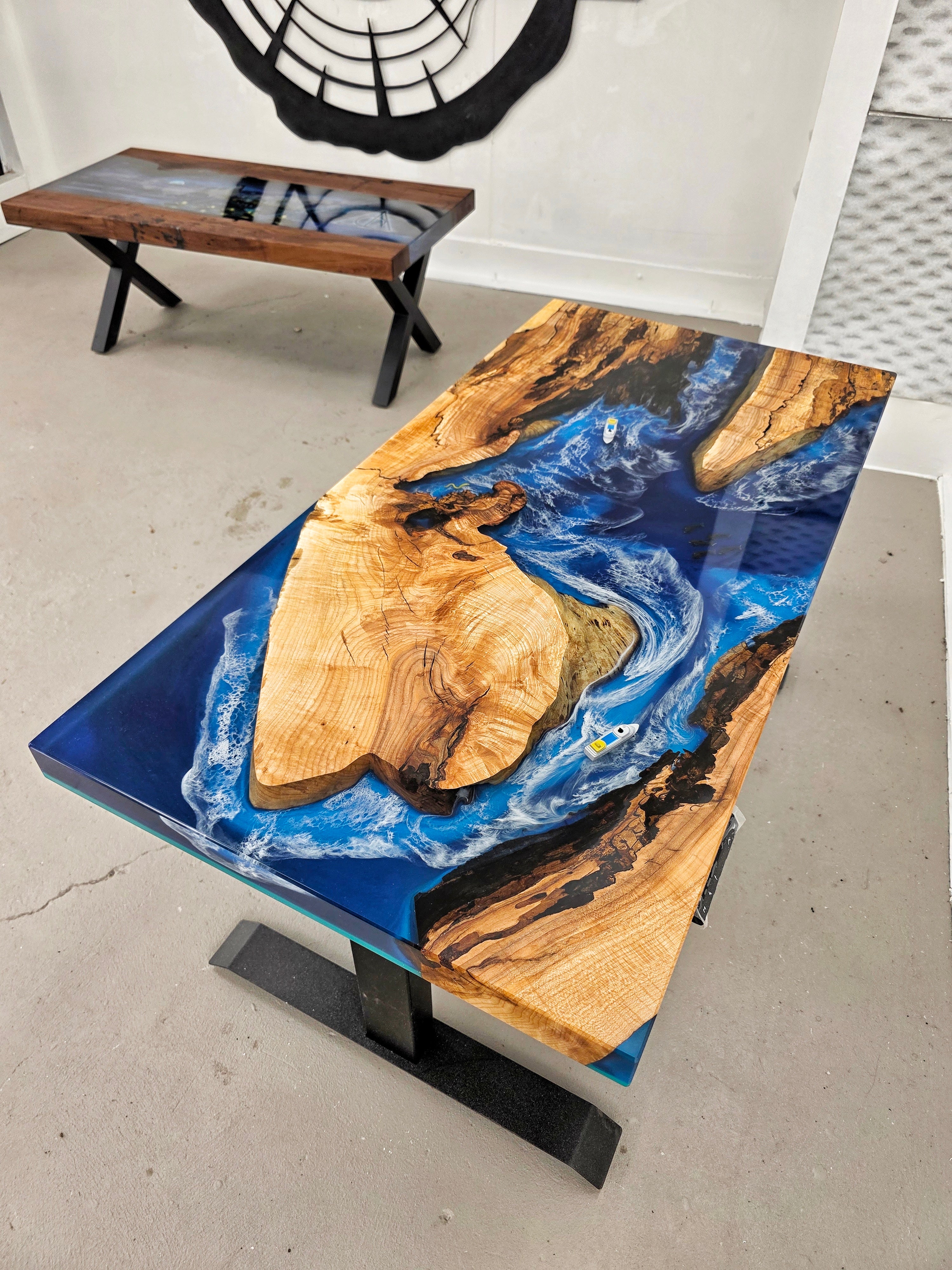Custom wood and epoxy desk with sit-stand mechanism. Wood is maple with tons of character and spalted; epoxy is inspired by the ocean with dark and light blue sections, crashing white waves, and memorabilia inclusions (toy-sized boats)